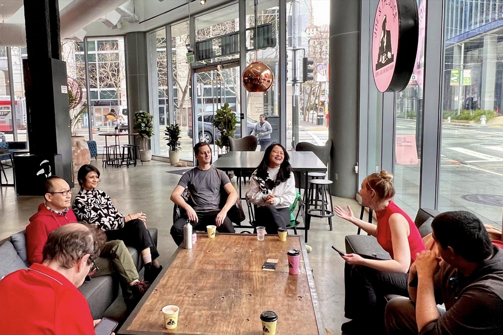 An SF Intellectuals discussion group gathered around a table at a caf&eacute;, with Ann talking